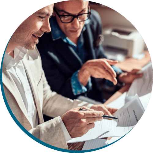 Two professionals reviewing financial documents together, emphasising collaboration and application assistance for business lending solutions.