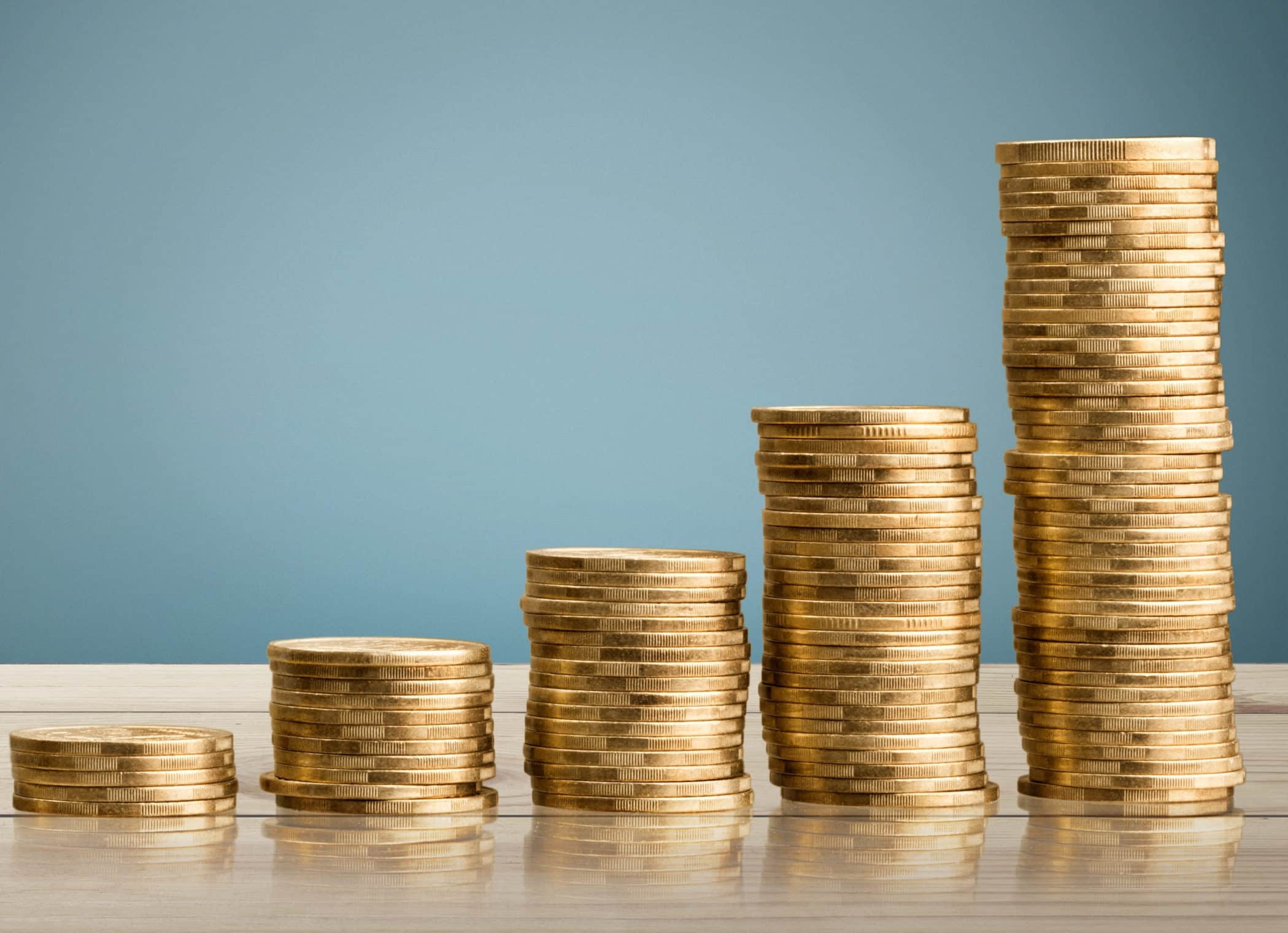 Golden,Coin,Stacks,On,A,White,Background Stacks of gold coins representing investment growth and interest accumulation in financial services.