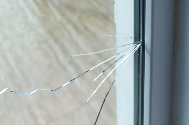 Broken glass pane in an old window frame, illustrating property damage and public liability for church halls.