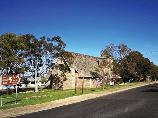 Historic countryside brick church building on a roadside, demonstrating church property insurance protection.