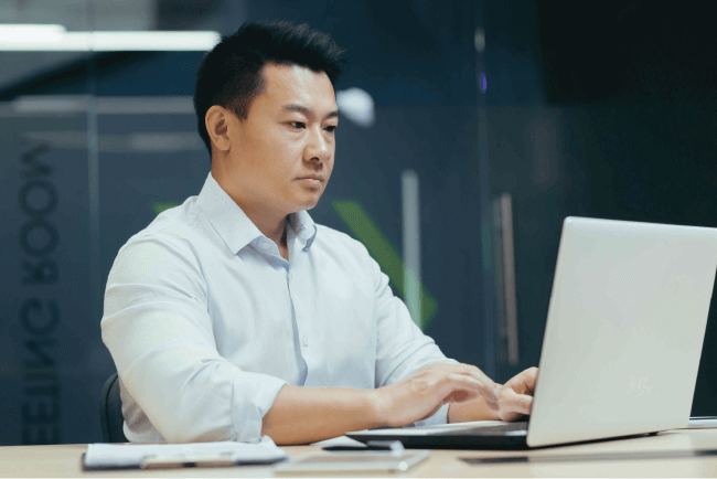 Office worker typing on a laptop, illustrating data protection and church cyber insurance requirements.