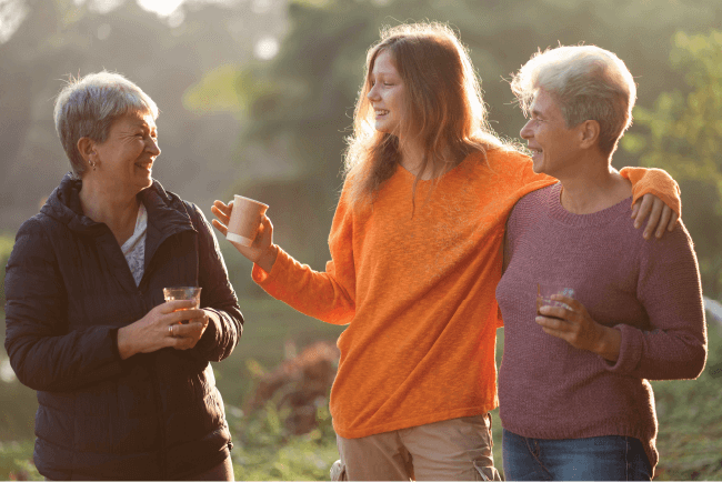 Care worker talking with elderly women outside a facility, illustrating tailored choices for aged care insurance.