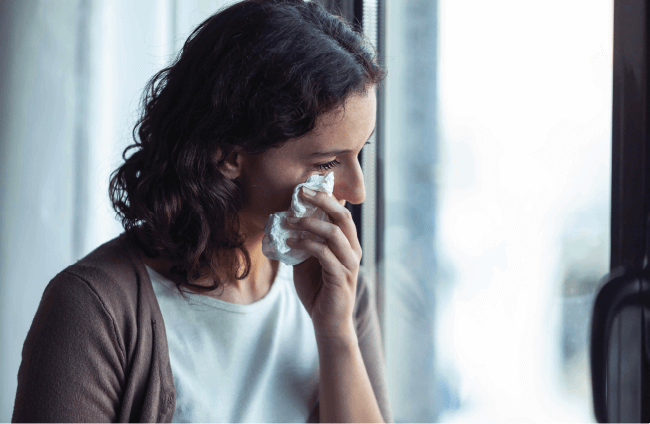 Distressed woman wiping her tears with a tissue, illustrating personal loss and professional indemnity risks for pastors.