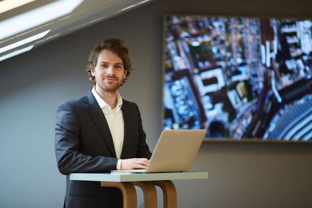 Real estate professional using a laptop at a standing desk, demonstrating building valuation and underinsurance risk.