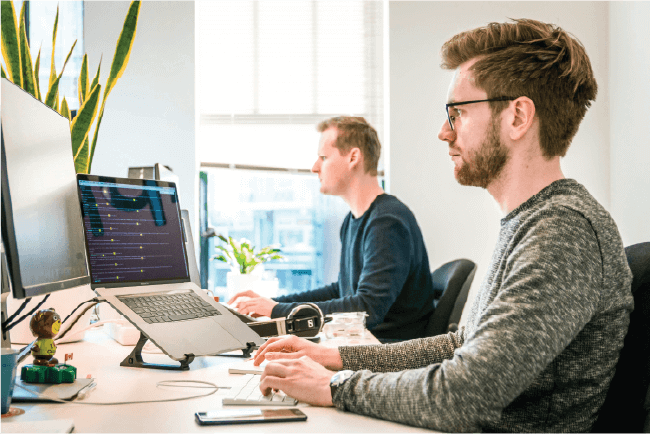 Office workers at desks analyzing data to manage risk and provide tailored church loan options.