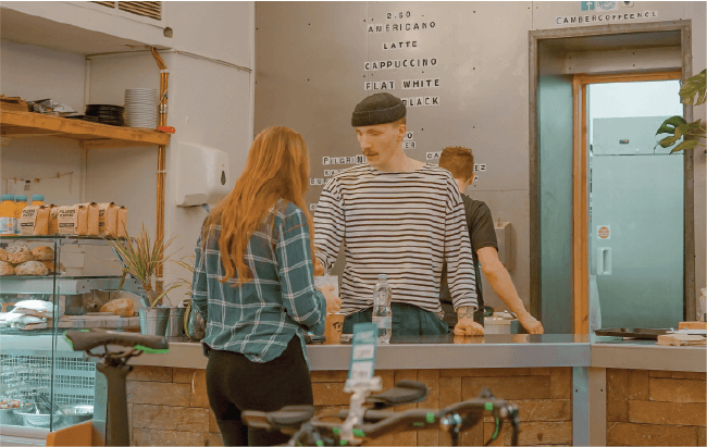 Customer ordering at a modern cafe counter, highlighting food relief initiatives and church coffee shop safety.