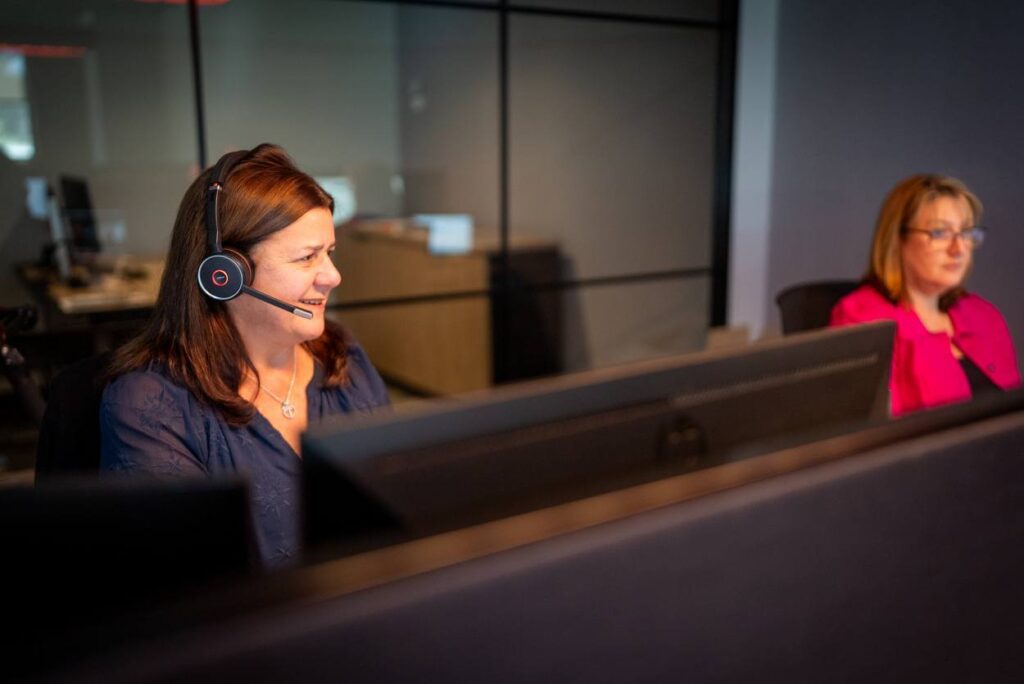 Customer service representatives with headsets assisting clients with ministry insurance plans and corporate claims.