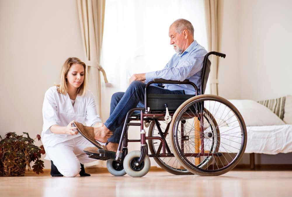 Care worker assisting a senior resident in a wheelchair, illustrating specialized aged care insurance risks.