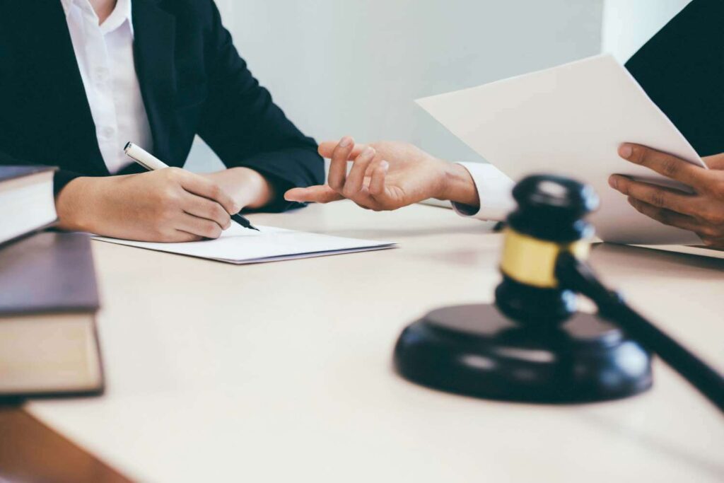 Legal team reviewing corporate documents with a gavel on the table, clarifying risks of lacking aged care insurance.